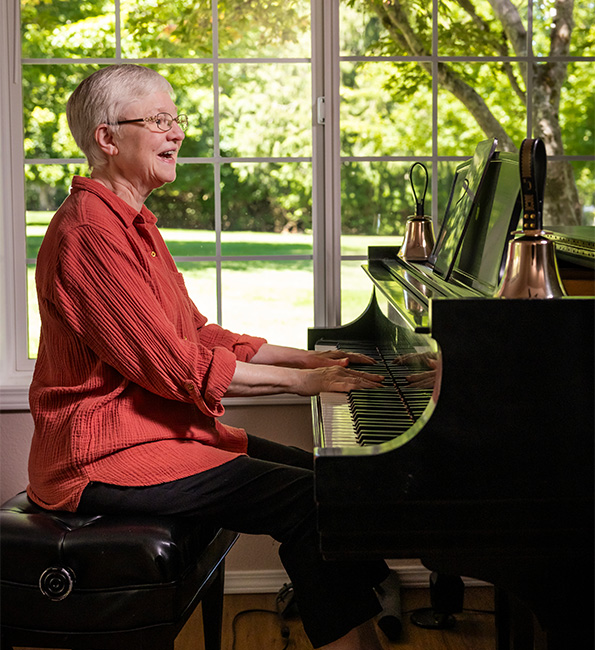 Marcia singing while playing a grand piano